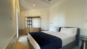 A modern bedroom with a large bed, a wooden wardrobe, and a built-in desk. - Apartment Luxury one bed one Bathroom (Barcelona)