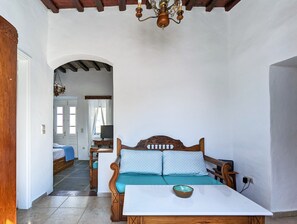 Cozy bedroom with a single bed, wooden headboard, and a small table.