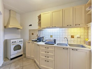 Kitchen area with oven, sink, and coffee maker.