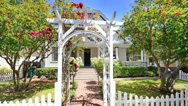 A white wooden archway leading to a house with a brick pathway. - Sonoma Victorian in Heart of Sonoma (Sonoma)