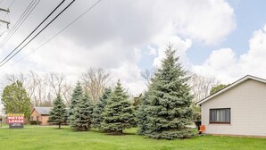 A motor lodge with a grassy lawn and several evergreen trees.