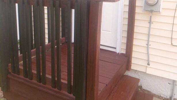 A wooden deck with a door and a utility box.