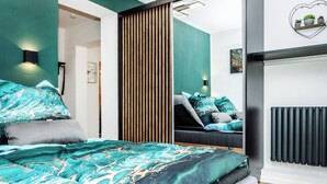 A modern bedroom with a large bed, a sliding door, a built-in wardrobe, and a radiator. - New and fully equipped Wonderful view (Saldenburg)