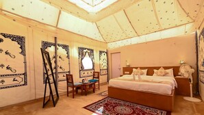 A bedroom with a bed, a desk, and chairs. - Shrinath Desert Camp (Jaisalmer)