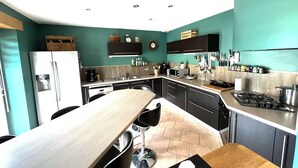 Una cocina compacta con una isla central, un refrigerador y una estufa a gas.