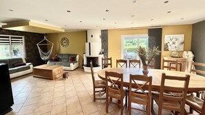 Un amplio salón con una mesa de comedor, sofás y una chimenea.