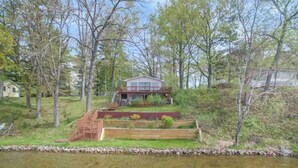Ein Haus mit Terrasse und Teich davor.