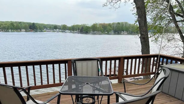 Eine Terrasse mit Tisch und Stühlen mit Blick auf einen See.