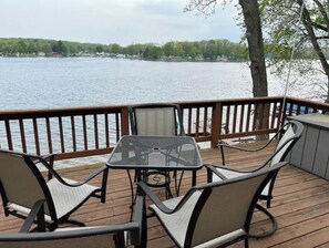 A deck with a table and chairs overlooking a lake. - Lakefront home away from home.
 (Lakeview)