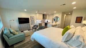 A modern hotel room with a large bed, a sofa, a desk, a kitchenette, and a TV. - Newly remodeled, heart of Seagrove Beach, 100 yards to beach! (Santa Rosa Beach)