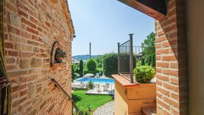 A brick building with a pool area visible through an open doorway. - Cozy apartment in Monte Rinaldo (Monte Rinaldo)