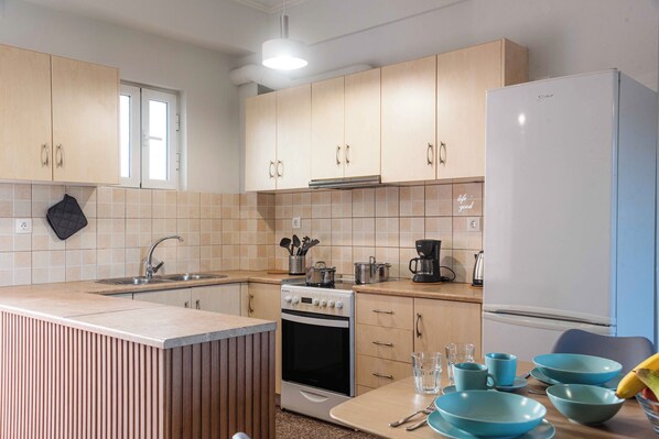 Una cocina moderna con armarios de madera, horno empotrado, refrigerador y ventana.