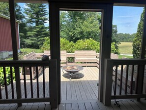 A wooden deck with a fire pit and benches, overlooking a green landscape. - Spacious Country Home - uniquely located for great family fun (Pine Knot)
