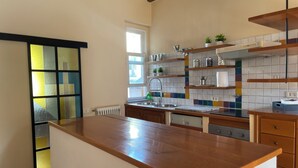 Eine Küche mit Holzausziehtisch, Spüle und Fenster.