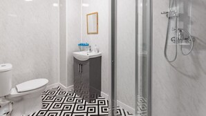 A modern bathroom with a toilet, sink, and shower.