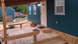 A wooden deck with a pergola, a door, and a window. - One bedroom cabin minutes from the Frio River and Garner State Park! (Leakey)