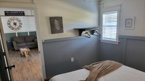 A bedroom with a bed, a small table, a couch, and a wall clock. - One bedroom cabin minutes from the Frio River and Garner State Park! (Leakey)