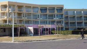 A multi-story building with balconies, a sign for 'L'Albatros Bar & Cafe', and a 'La Salsa Food' restaurant. - Seaview appartment with direct acces to the beach (Palavas-les-Flots)
