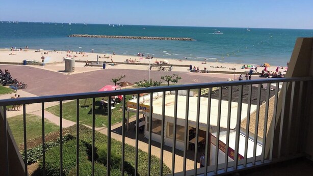 A beach view from a balcony with a clear sky, a sandy beach, and a few boats in the distance. - Seaview appartment with direct acces to the beach (Palavas-les-Flots)