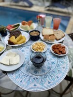 Una mesa con diferentes alimentos para el desayuno, como pan, huevos y una taza de café.