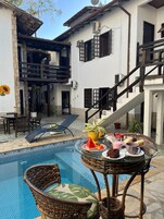 Una piscina al aire libre, sombrillas, sillones reclinables de piscina