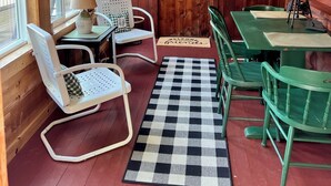 A cozy cabin interior with wooden walls, a checkered rug, and a 'Keep it Simple' sign.