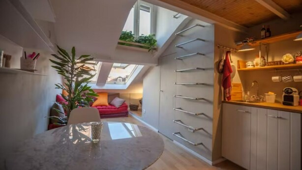 A compact kitchen with white cabinets, a dining table with a glass top, and a skylight above. - GuestHost - Mansardina in Corso Como in Milan, adjacent Brera (Milano)