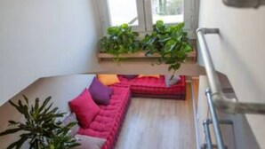 A modern interior with a red sofa, a wooden bench, and potted plants. - GuestHost - Mansardina in Corso Como in Milan, adjacent Brera (Milano)