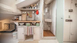 A compact kitchen with a wooden countertop, a sink, and a small storage cabinet.