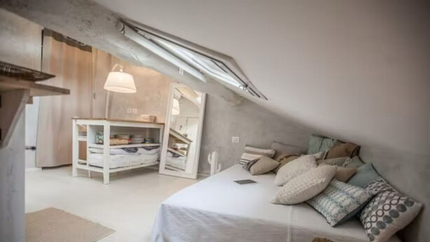 A bedroom with a bunk bed, a bedside table, a lamp, and a wardrobe.