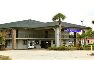 Un motel de dos pisos con un letrero que dice 'HOME INN & SUITES'.