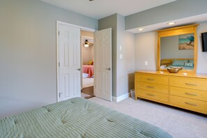 Un dormitorio con una cama, un aparador y una puerta que da a otra habitación.