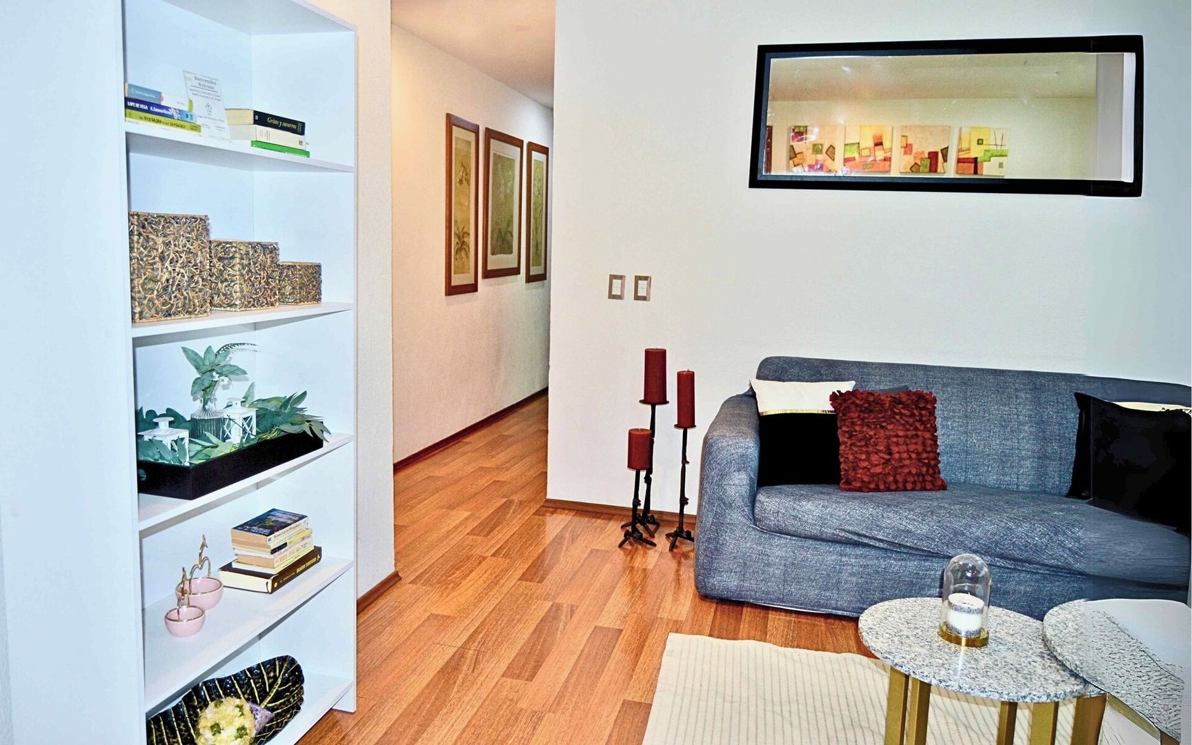 Vista del pasillo hacia las recámaras y baño común desde la sala. En la sala encuentras algunos libros y objetos decorativos. 
También tienes información del WiFi y un código QR para facilitar tu conexión.