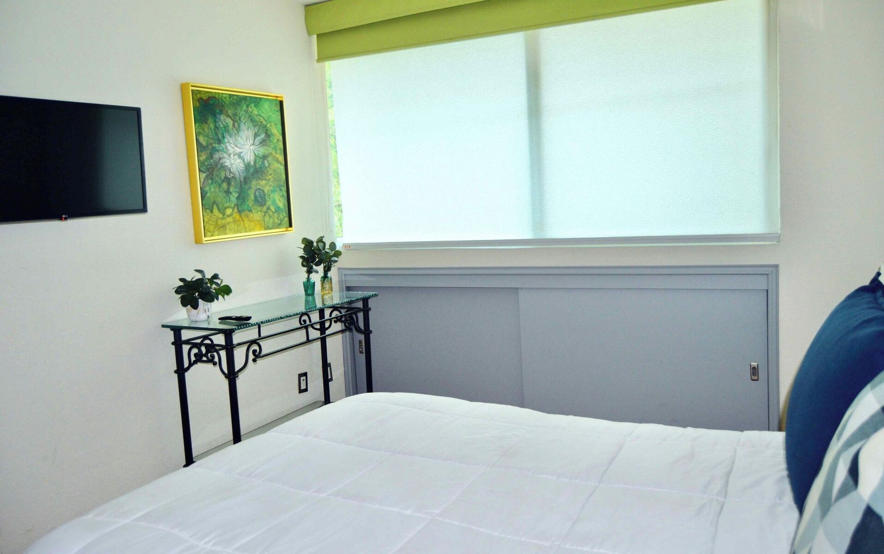 Tercera recámara con cama matrimonial. Televisión Smart con acceso a canales locales y apps de streaming. La recámara tiene persianas traslúcidas y blackout. 