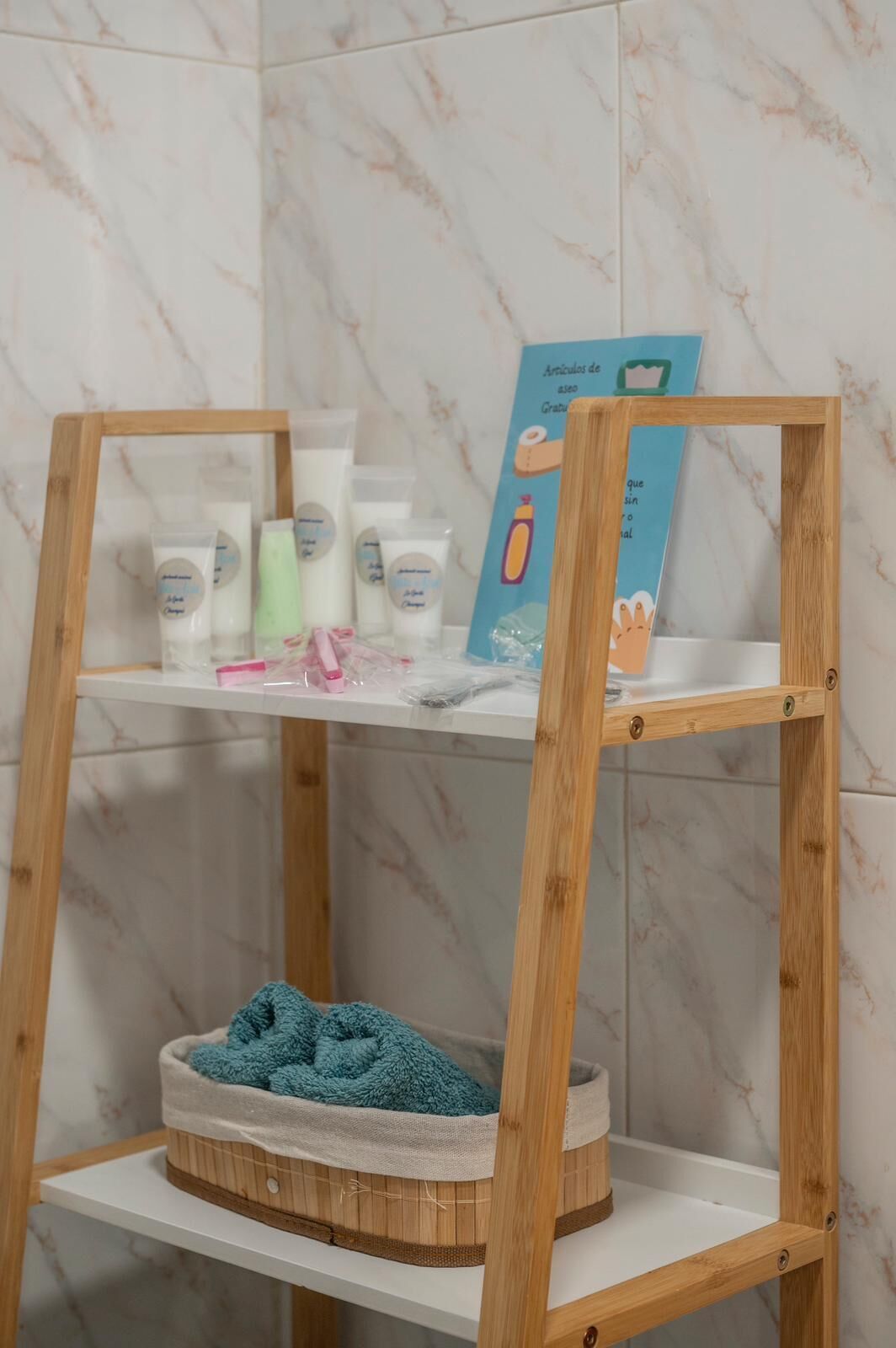 Un estante de madera con una toalla azul en una cesta, un marco de madera y un letrero azul con ilustraciones.