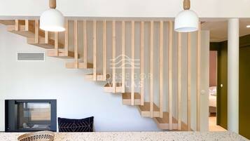 Un interno moderno con una scala, un'area pranzo e vista su un'altra stanza.