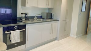 Una cocina moderna con electrodomésticos de acero inoxidable, horno empotrado y microondas.