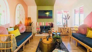 A cozy living room with a sofa set, a flat-screen TV, and decorative plants. - Welcome to The Pink Cabana, where modern Moroccan meets luxe desert vibes. (Indio)