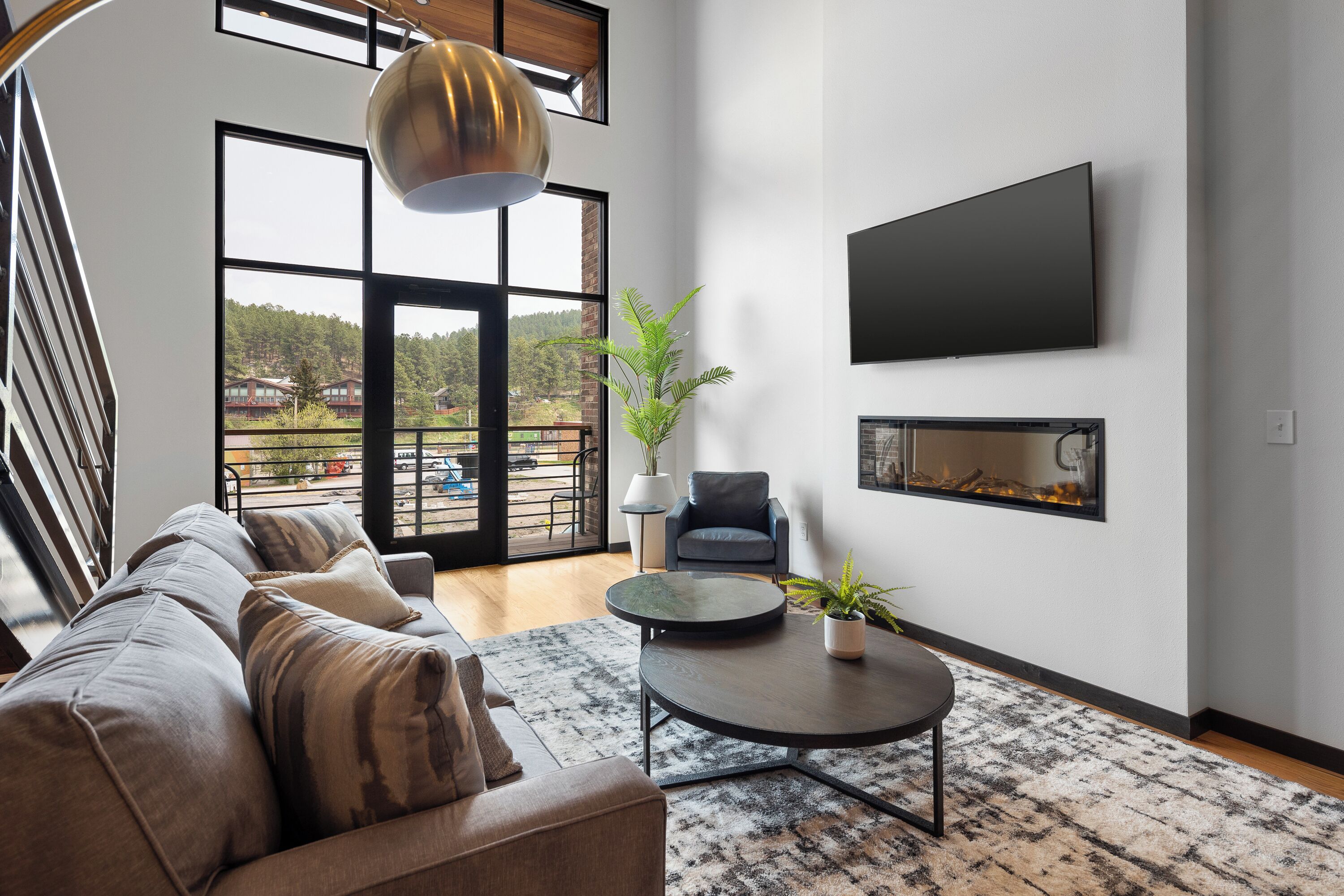 A modern living room with a sofa, a coffee table, a TV, and a fireplace.