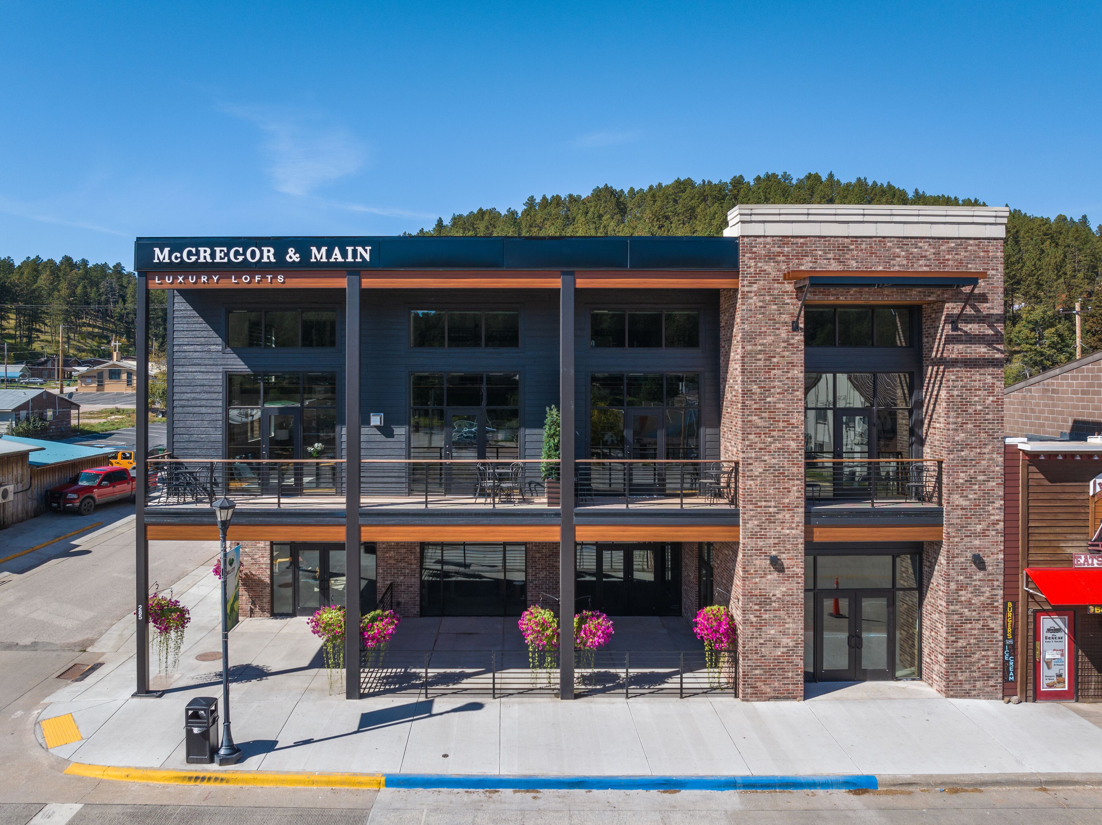 A two-story building with a sign reading "McGregor & Main Luxury Lofts".