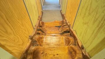 A wooden interior hallway with a central wooden bench.