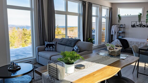 Una sala de estar moderna con un sofá, una mesa de comedor y vistas al exterior.