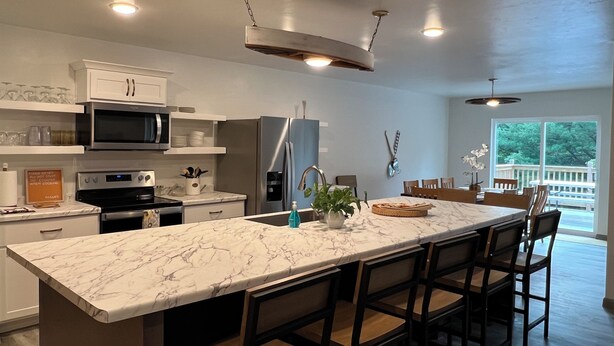 Et moderne køkken med en marmorø, rustfrie stålapparater og udsigt til det fri.