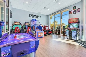 A gaming area with various arcade machines, a foosball table, and a sign labeled 'GAMING ZONE.'