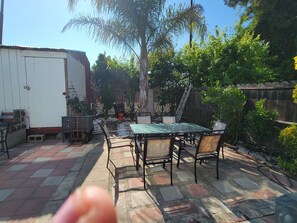 A patio with a table and chairs, a white building, and a wooden fence. - Victoria home near to downtown  oakland!!! (Oakland)