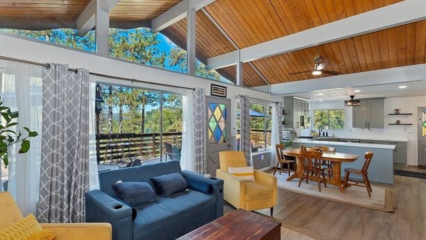 A spacious living area with a sofa, chairs, and a dining table. - Dogs are family also 240° Lakefront View Spacious modern Family Retreat sleeps 8 (Crestline)