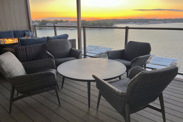 Top floor covered deck w/ expansive lake views, fire table, plush seating for 12