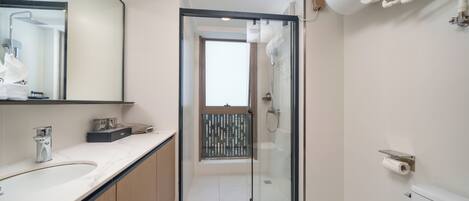 A modern bathroom with a glass shower enclosure, a white toilet, and a marble sink.