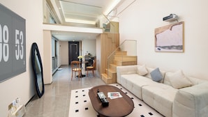 En moderne stue med sofa, sofabord og trappe.