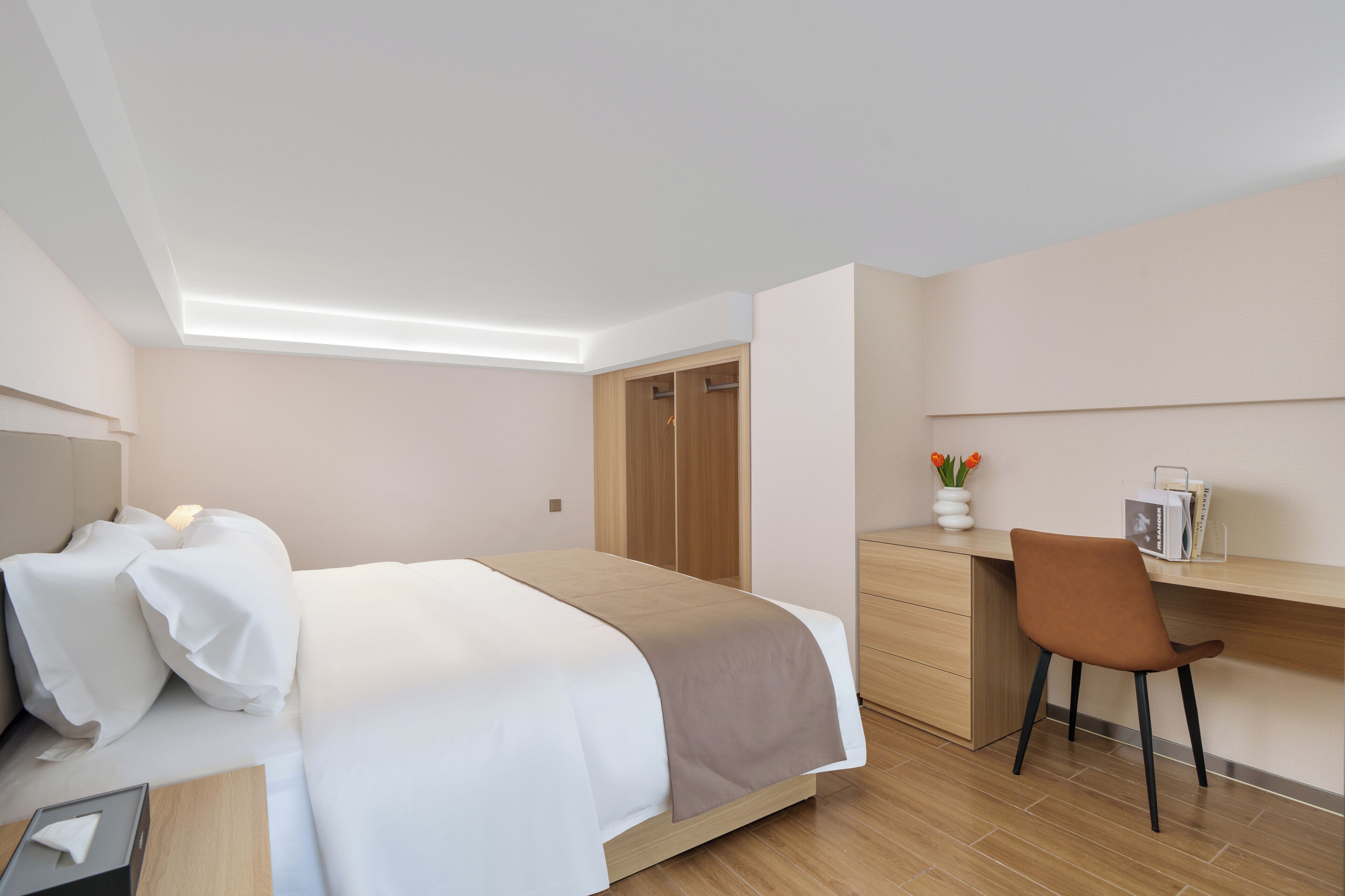 Una habitación de hotel moderna con una cama, un escritorio y una silla.